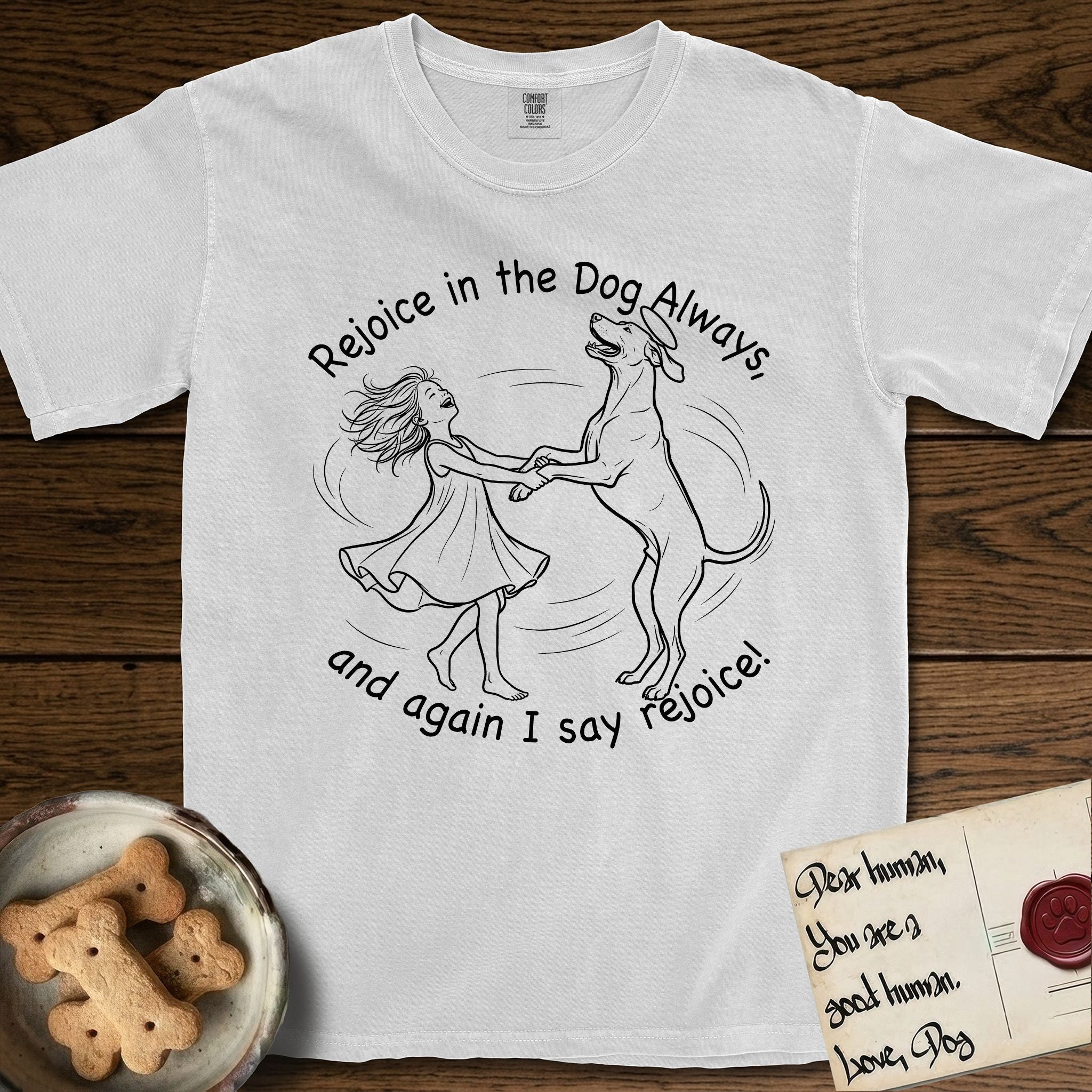 Rejoice in the Dog Rhodesian Ridgeback T-Shirt flat lay in White, featuring a sparse pen-and-ink illustration of a girl and her Rhodesian Ridgeback spinning together, hands and paws clasped.