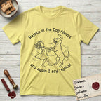 Rejoice in the Dog Rottweiler T-Shirt flat lay in Cornsilk, featuring a sparse pen-and-ink illustration of a girl and her Rottweiler dancing on her hind legs, both heads thrown back in joy.