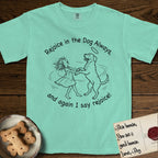 Rejoice in the Dog Rottweiler T-Shirt flat lay in Island Reef, featuring a sparse pen-and-ink illustration of a girl and her Rottweiler dancing on her hind legs, both heads thrown back in joy.