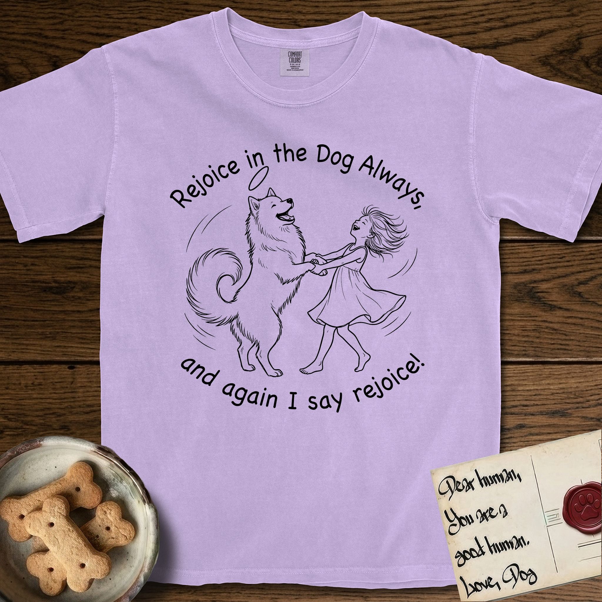 Rejoice in the Dog Samoyed T-Shirt flat lay in Orchid, featuring a sparse pen-and-ink illustration of a girl and her smiling Samoyed spinning together, hands and paws clasped.