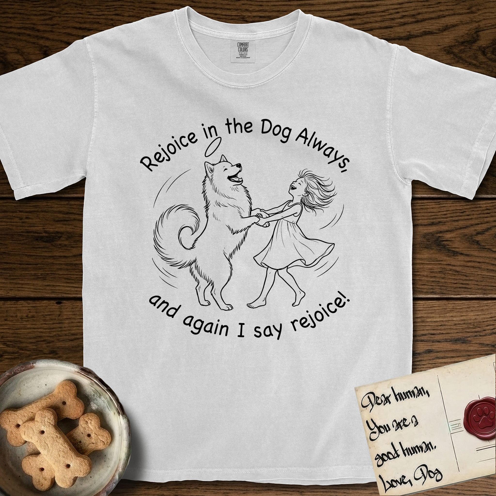 Rejoice in the Dog Samoyed T-Shirt flat lay in White, featuring a sparse pen-and-ink illustration of a girl and her smiling Samoyed spinning together, hands and paws clasped.