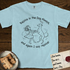 Rejoice in the Dog Whippet T-Shirt flat lay in Chambray, featuring a sparse pen-and-ink illustration of a girl and her Whippet dancing on his hind legs, both heads thrown back in joy.