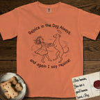 Rejoice in the Dog Whippet T-Shirt flat lay in Melon, featuring a sparse pen-and-ink illustration of a girl and her Whippet dancing on his hind legs, both heads thrown back in joy.
