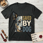 Saved by Dog Australian Cattle Dog T-Shirt flat lay in Black, featuring half an Australian Cattle Dog's face in distressed vintage screen print, blue-speckled with tan points and one amber eye, cropped down the centerline beside bold stacked block lettering.