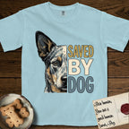 Saved by Dog Australian Cattle Dog T-Shirt flat lay in Chambray, featuring half an Australian Cattle Dog's face in distressed vintage screen print, blue-speckled with tan points and one amber eye, cropped down the centerline beside bold stacked block lettering.