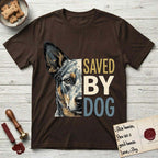 Saved by Dog Australian Cattle Dog T-Shirt flat lay in Dark Chocolate, featuring half an Australian Cattle Dog's face in distressed vintage screen print, blue-speckled with tan points and one amber eye, cropped down the centerline beside bold stacked block lettering.