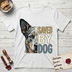 Saved by Dog Australian Cattle Dog T-Shirt flat lay in White, featuring half an Australian Cattle Dog's face in distressed vintage screen print, blue-speckled with tan points and one amber eye, cropped down the centerline beside bold stacked block lettering.