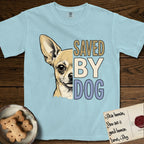 Saved by Dog Chihuahua T-Shirt flat lay in Chambray, featuring half a fawn Chihuahua's face in distressed vintage screen print, one huge upright ear and an enormous dark eye, cropped down the centerline beside bold stacked block lettering.