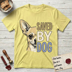 Saved by Dog Chihuahua T-Shirt flat lay in Cornsilk, featuring half a fawn Chihuahua's face in distressed vintage screen print, one huge upright ear and an enormous dark eye, cropped down the centerline beside bold stacked block lettering.