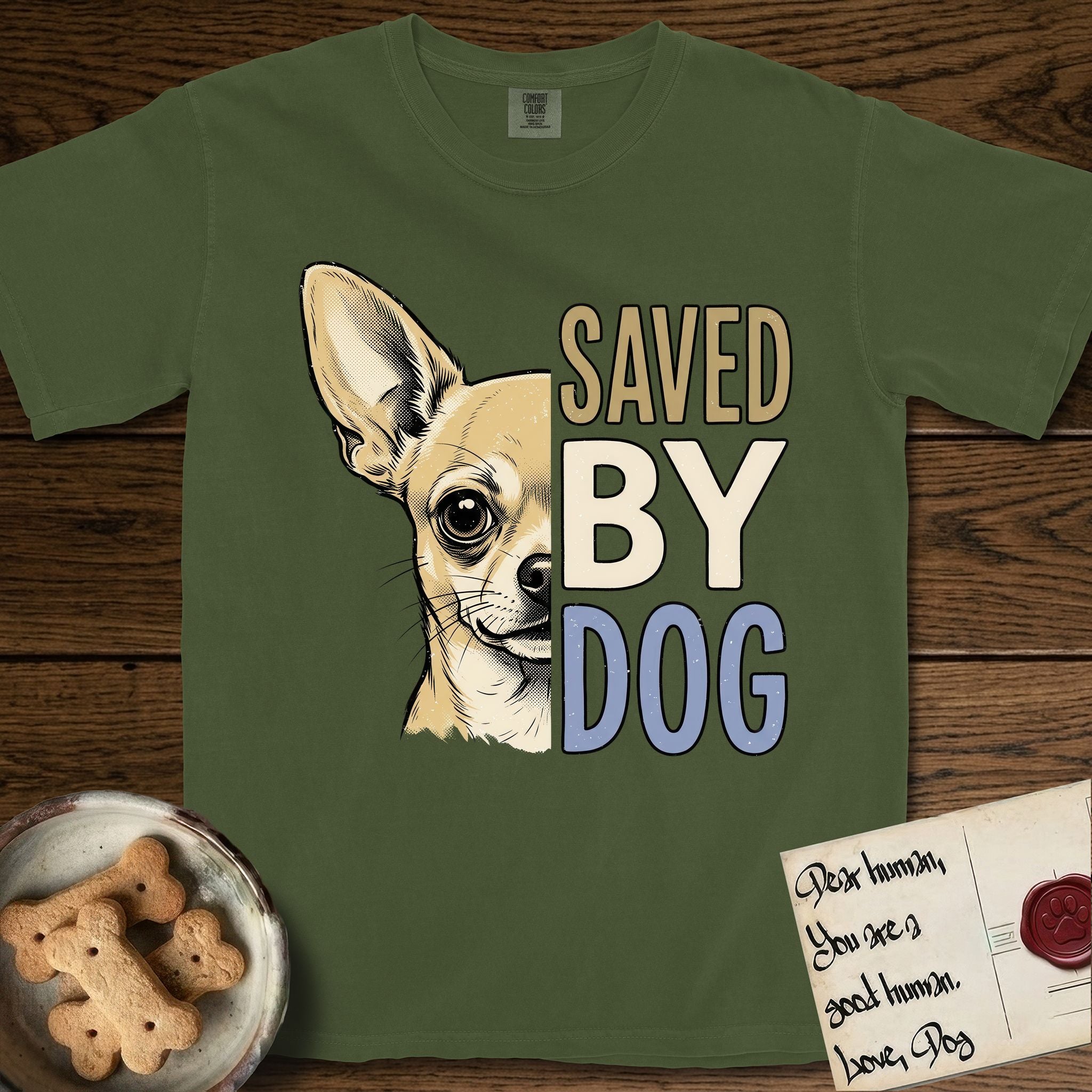 Saved by Dog Chihuahua T-Shirt flat lay in Hemp, featuring half a fawn Chihuahua's face in distressed vintage screen print, one huge upright ear and an enormous dark eye, cropped down the centerline beside bold stacked block lettering.