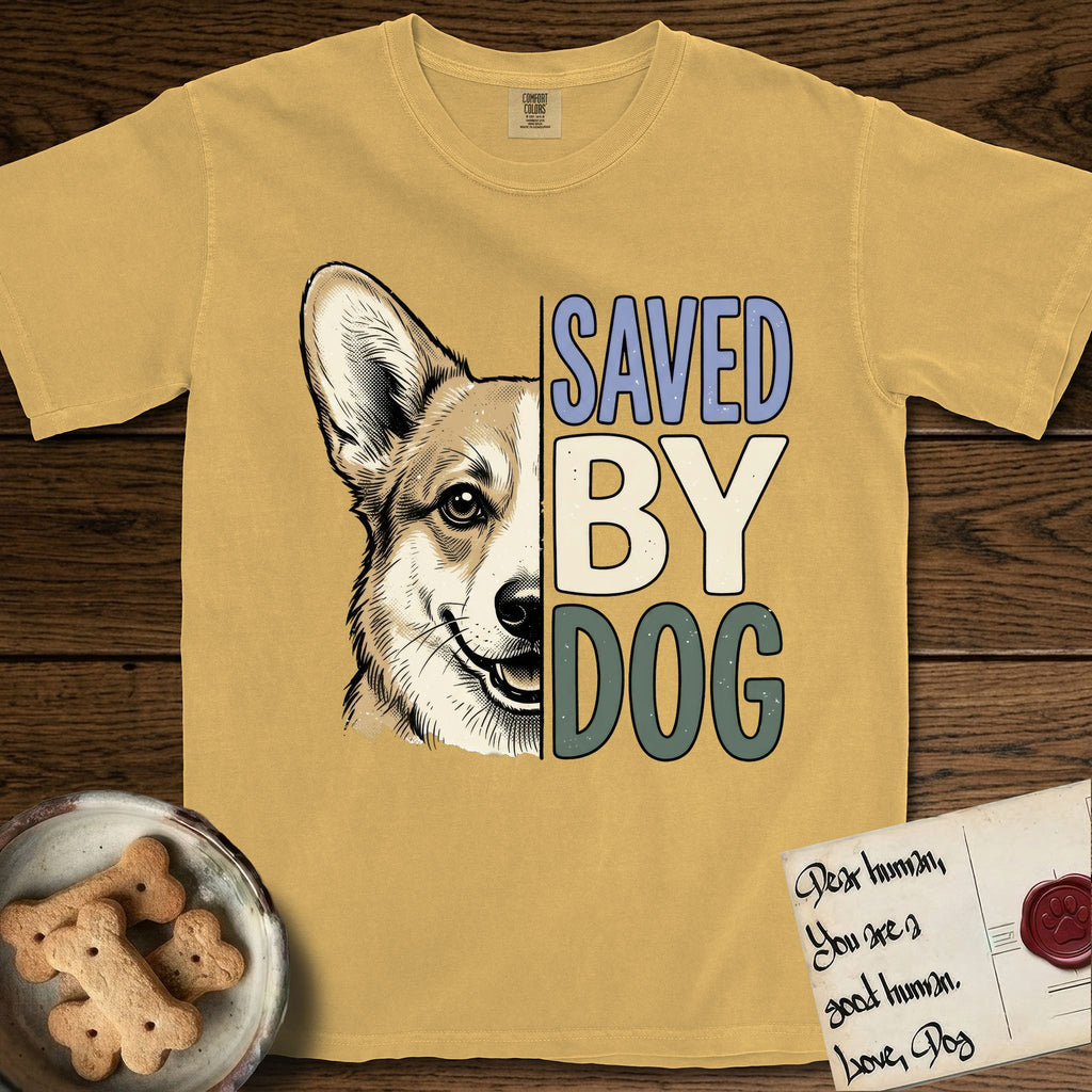 Saved by Dog Corgi T-Shirt flat lay in Mustard, featuring half a tan-and-cream Corgi's face in distressed vintage screen print, one upright ear and a foxy grin, cropped down the centerline beside bold stacked block lettering.