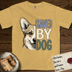 Saved by Dog Corgi T-Shirt flat lay in Mustard, featuring half a tan-and-cream Corgi's face in distressed vintage screen print, one upright ear and a foxy grin, cropped down the centerline beside bold stacked block lettering.