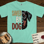 Saved by Dog Doberman T-Shirt flat lay in Island Reef, featuring half a black-and-rust Doberman's face in distressed vintage screen print, natural uncropped ears and a steady eye, cropped down the centerline beside bold stacked block lettering.