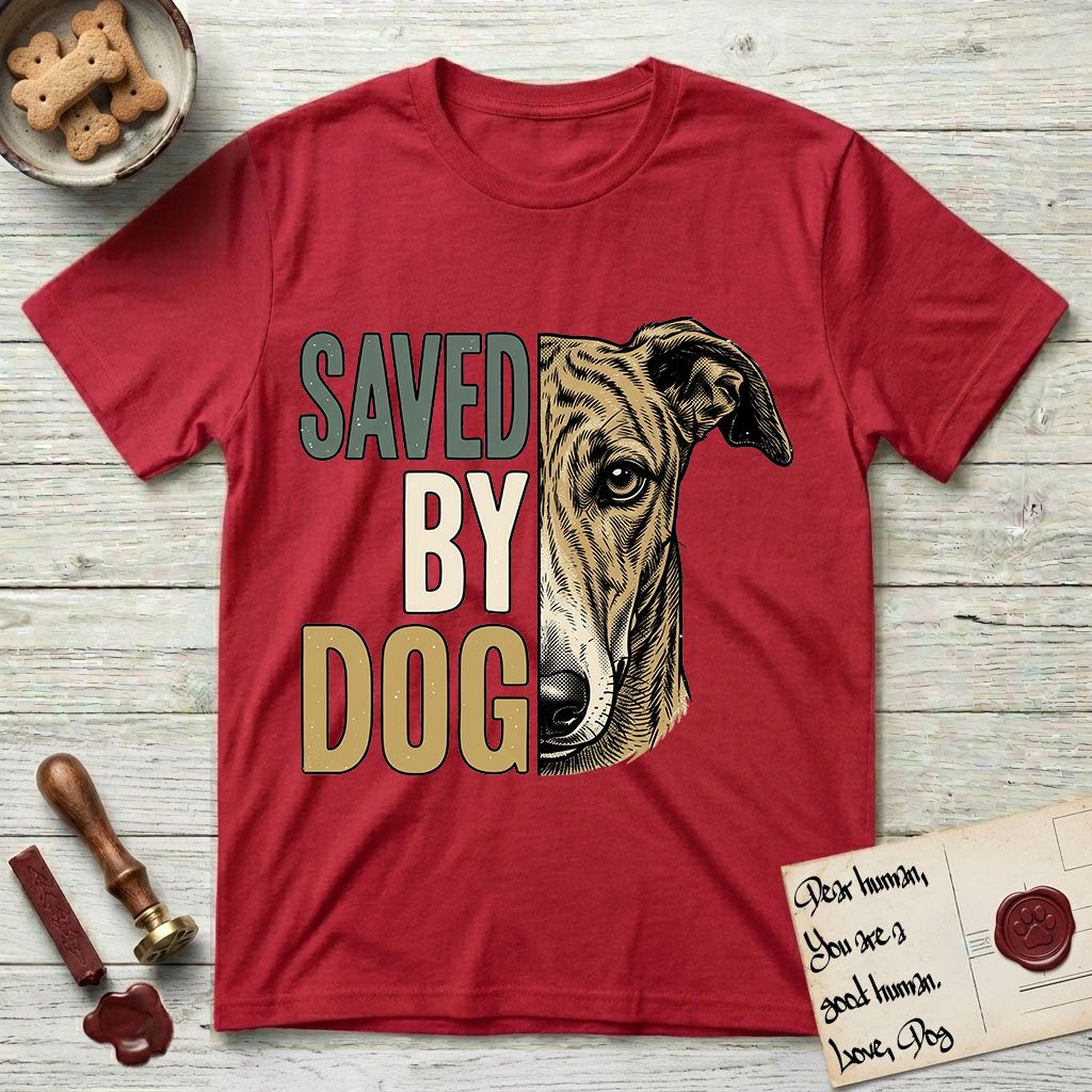 Saved by Dog Galgo T-Shirt flat lay in Cherry Red, featuring half a brindle Galgo's face in distressed vintage screen print, a folded rose ear and a gentle eye, cropped down the centerline beside bold stacked block lettering.