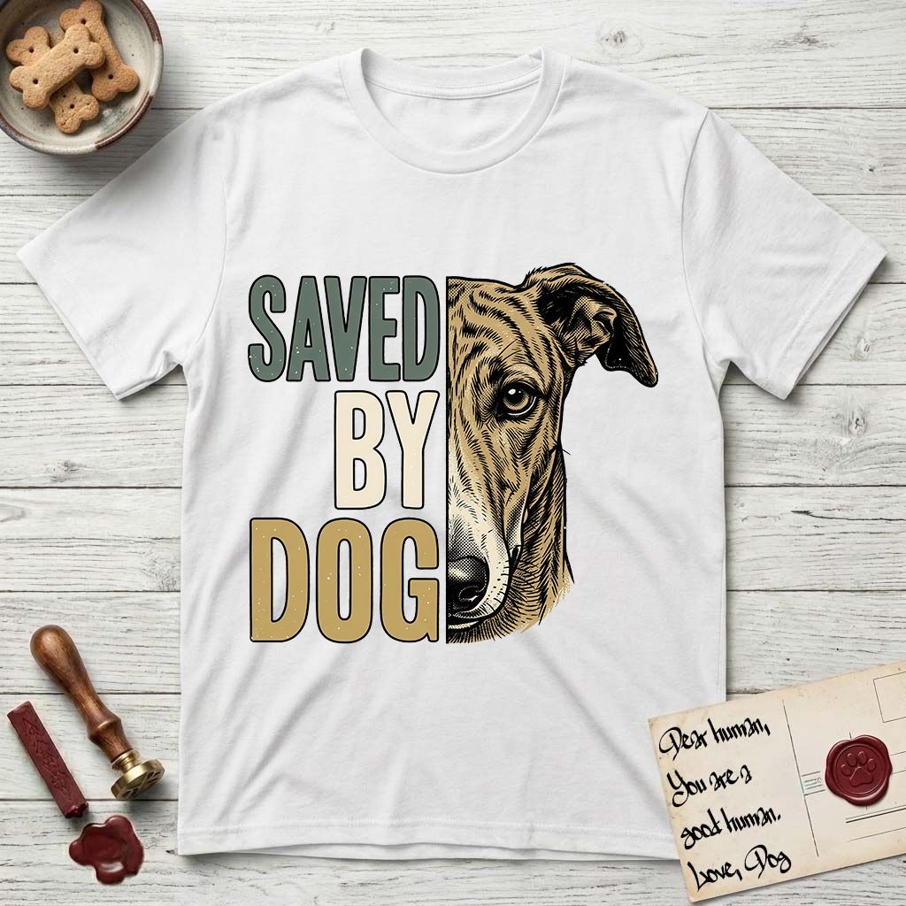 Saved by Dog Galgo T-Shirt flat lay in White, featuring half a brindle Galgo's face in distressed vintage screen print, a folded rose ear and a gentle eye, cropped down the centerline beside bold stacked block lettering.