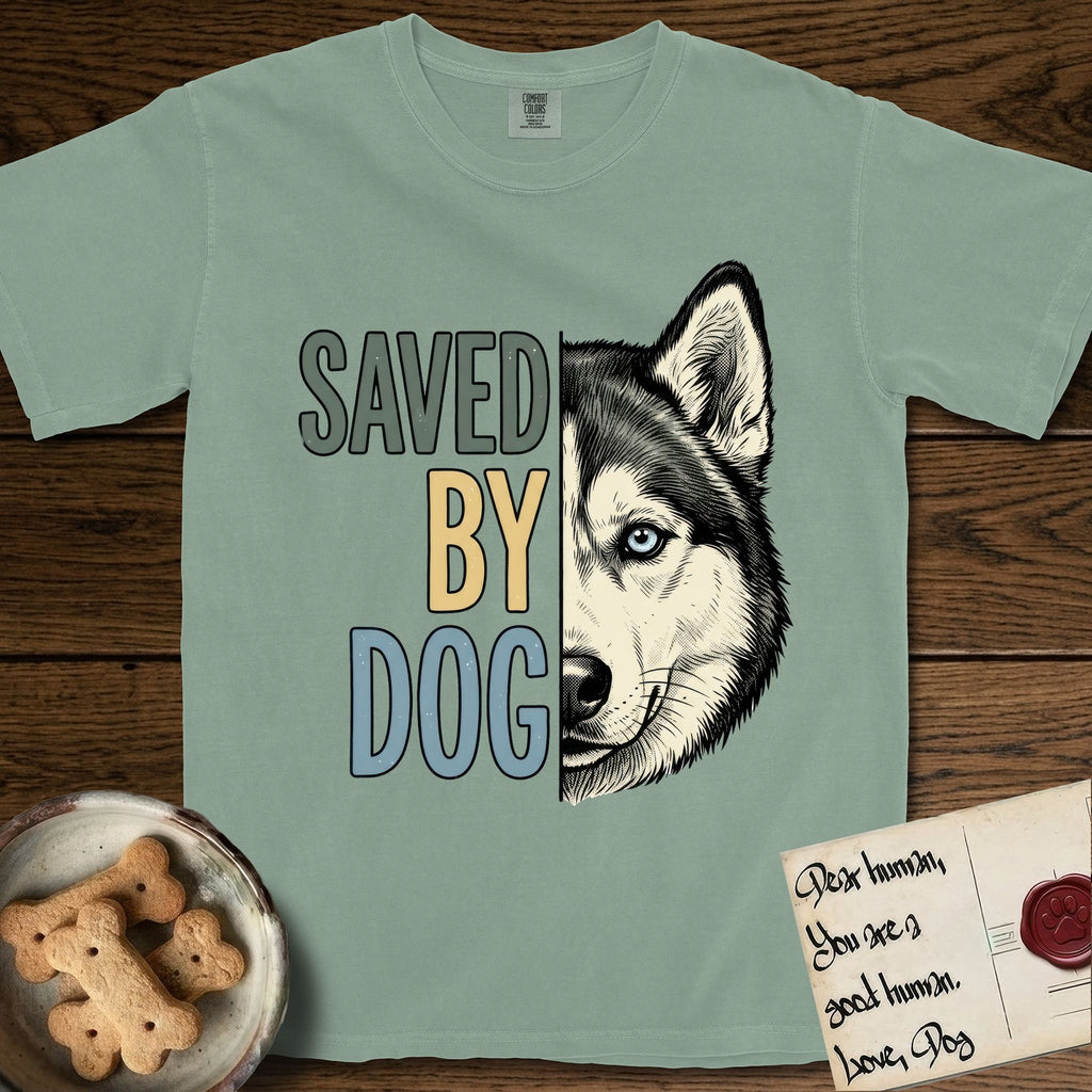 Saved by Dog Husky T-Shirt flat lay in Bay, featuring half a black-and-white Husky's face in distressed vintage screen print, one pale ice-blue eye, cropped down the centerline beside bold stacked block lettering.