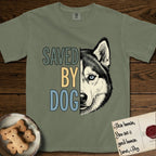 Saved by Dog Husky T-Shirt flat lay in Sage, featuring half a black-and-white Husky's face in distressed vintage screen print, one pale ice-blue eye, cropped down the centerline beside bold stacked block lettering.