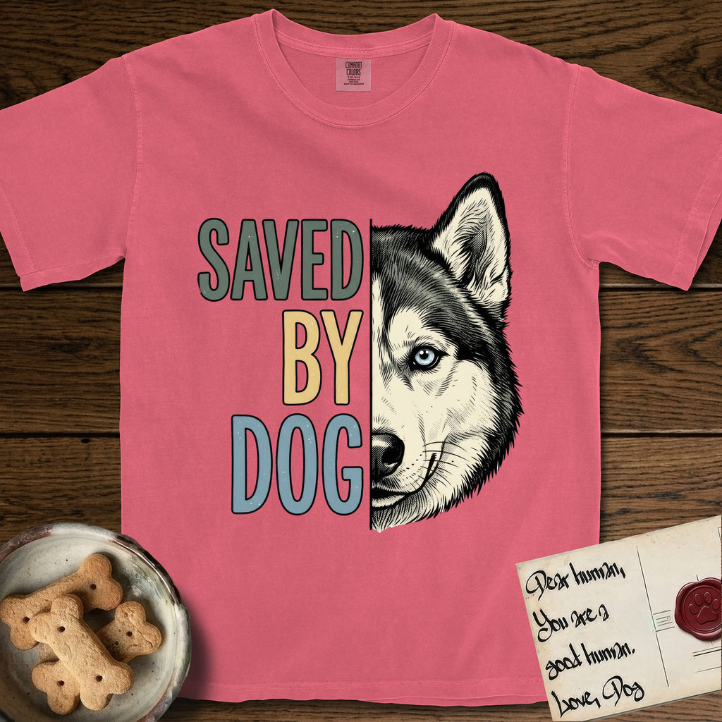 Saved by Dog Husky T-Shirt flat lay in Watermelon, featuring half a black-and-white Husky's face in distressed vintage screen print, one pale ice-blue eye, cropped down the centerline beside bold stacked block lettering.