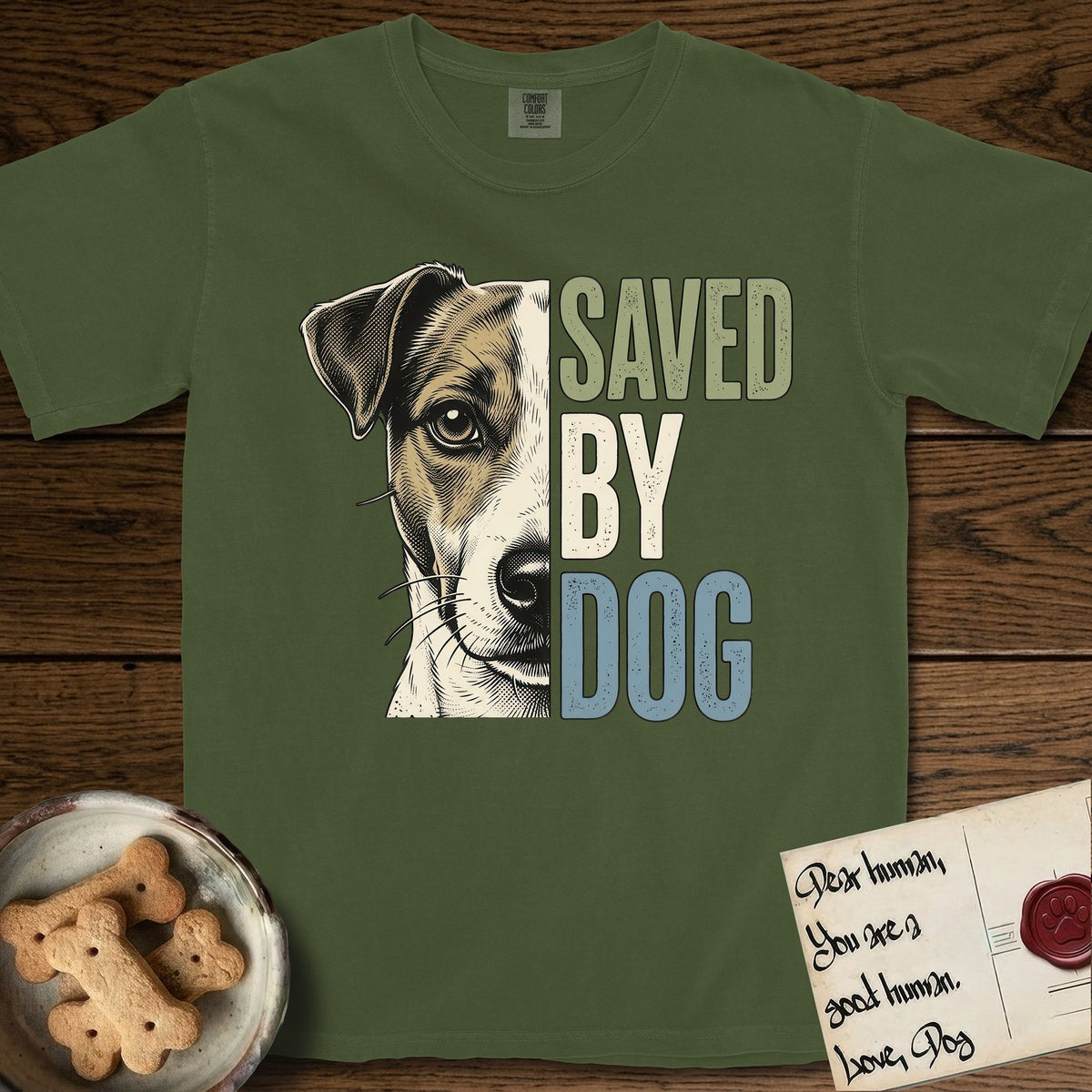 Saved by Dog Jack Russell T-Shirt flat lay in Hemp, featuring half a tan-and-white Jack Russell's face in distressed vintage screen print, a folded ear with a dark patch and forward whiskers, cropped down the centerline beside bold stacked block lettering.