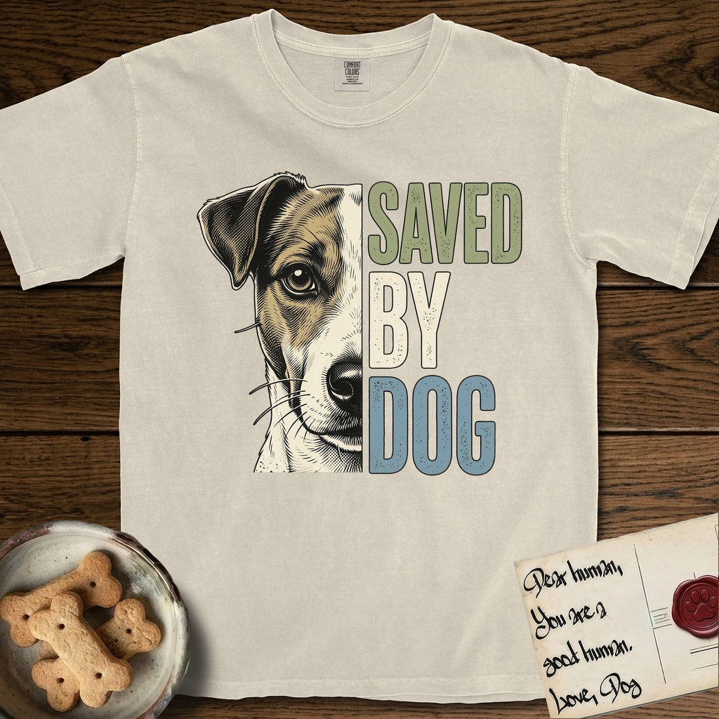 Saved by Dog Jack Russell T-Shirt flat lay in Ivory, featuring half a tan-and-white Jack Russell's face in distressed vintage screen print, a folded ear with a dark patch and forward whiskers, cropped down the centerline beside bold stacked block lettering.