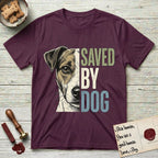 Saved by Dog Jack Russell T-Shirt flat lay in Maroon, featuring half a tan-and-white Jack Russell's face in distressed vintage screen print, a folded ear with a dark patch and forward whiskers, cropped down the centerline beside bold stacked block lettering.