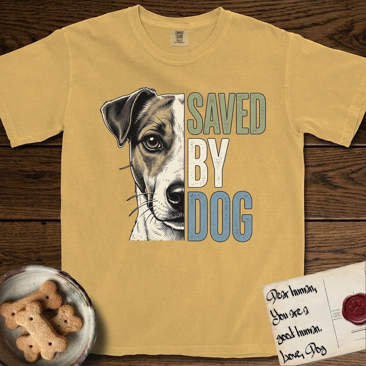 Saved by Dog Jack Russell T-Shirt flat lay in Mustard, featuring half a tan-and-white Jack Russell's face in distressed vintage screen print, a folded ear with a dark patch and forward whiskers, cropped down the centerline beside bold stacked block lettering.