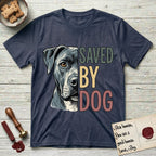 Saved by Dog Pitbull T-Shirt flat lay in Heather Navy, featuring half a blue-grey Pitbull's face in distressed vintage screen print, one warm amber eye, cropped down the centerline beside bold stacked block lettering.