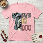 Saved by Dog Pitbull T-Shirt flat lay in Light Pink, featuring half a blue-grey Pitbull's face in distressed vintage screen print, one warm amber eye, cropped down the centerline beside bold stacked block lettering.