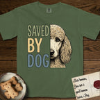 Saved by Dog Poodle T-Shirt flat lay in Moss, featuring half an apricot Poodle's face in distressed vintage screen print, soft natural curls and a knowing eye, cropped down the centerline beside bold stacked block lettering.