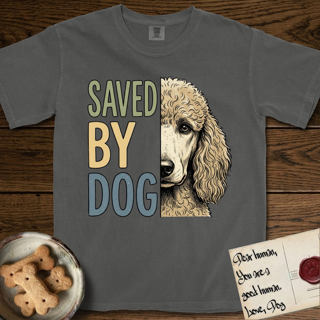 Saved by Dog Poodle T-Shirt flat lay in Pepper, featuring half an apricot Poodle's face in distressed vintage screen print, soft natural curls and a knowing eye, cropped down the centerline beside bold stacked block lettering.