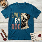 Saved by Dog Pug T-Shirt flat lay in Antique Sapphire, featuring half a fawn Pug's face in distressed vintage screen print, a dark mask and one large round eye, cropped down the centerline beside bold stacked block lettering.