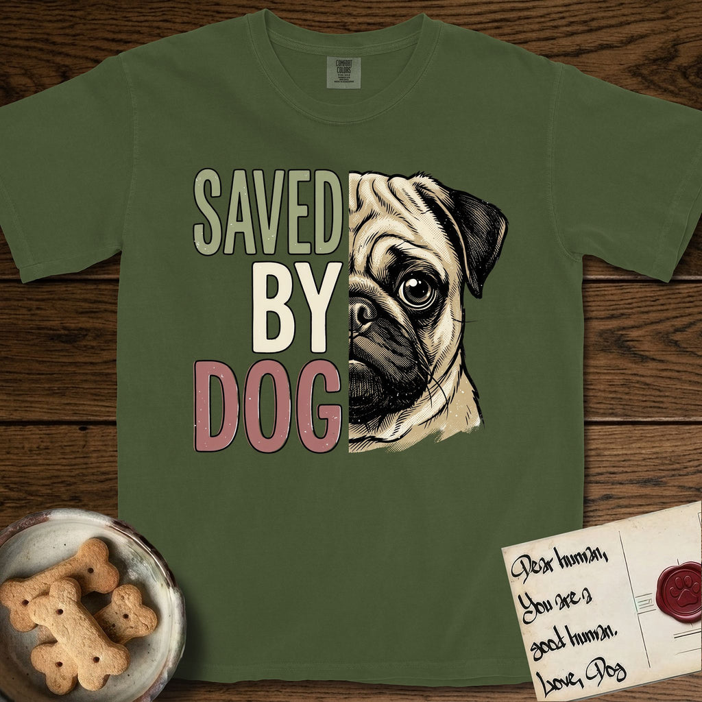 Saved by Dog Pug T-Shirt flat lay in Hemp, featuring half a fawn Pug's face in distressed vintage screen print, a dark mask and one large round eye, cropped down the centerline beside bold stacked block lettering.