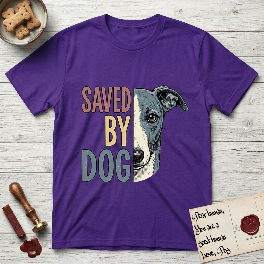 Saved by Dog Whippet T-Shirt flat lay in Purple, featuring half a blue-grey Whippet's face in distressed vintage screen print, a folded rose ear and a large liquid eye, cropped down the centerline beside bold stacked block lettering.