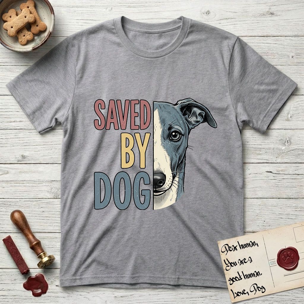 Saved by Dog Whippet T-Shirt flat lay in Sport Grey, featuring half a blue-grey Whippet's face in distressed vintage screen print, a folded rose ear and a large liquid eye, cropped down the centerline beside bold stacked block lettering.
