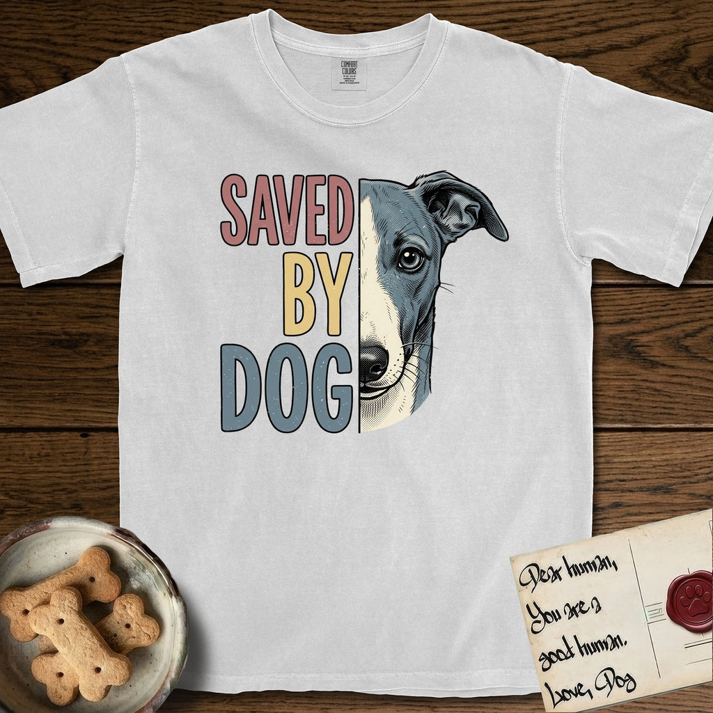 Saved by Dog Whippet T-Shirt flat lay in White, featuring half a blue-grey Whippet's face in distressed vintage screen print, a folded rose ear and a large liquid eye, cropped down the centerline beside bold stacked block lettering.