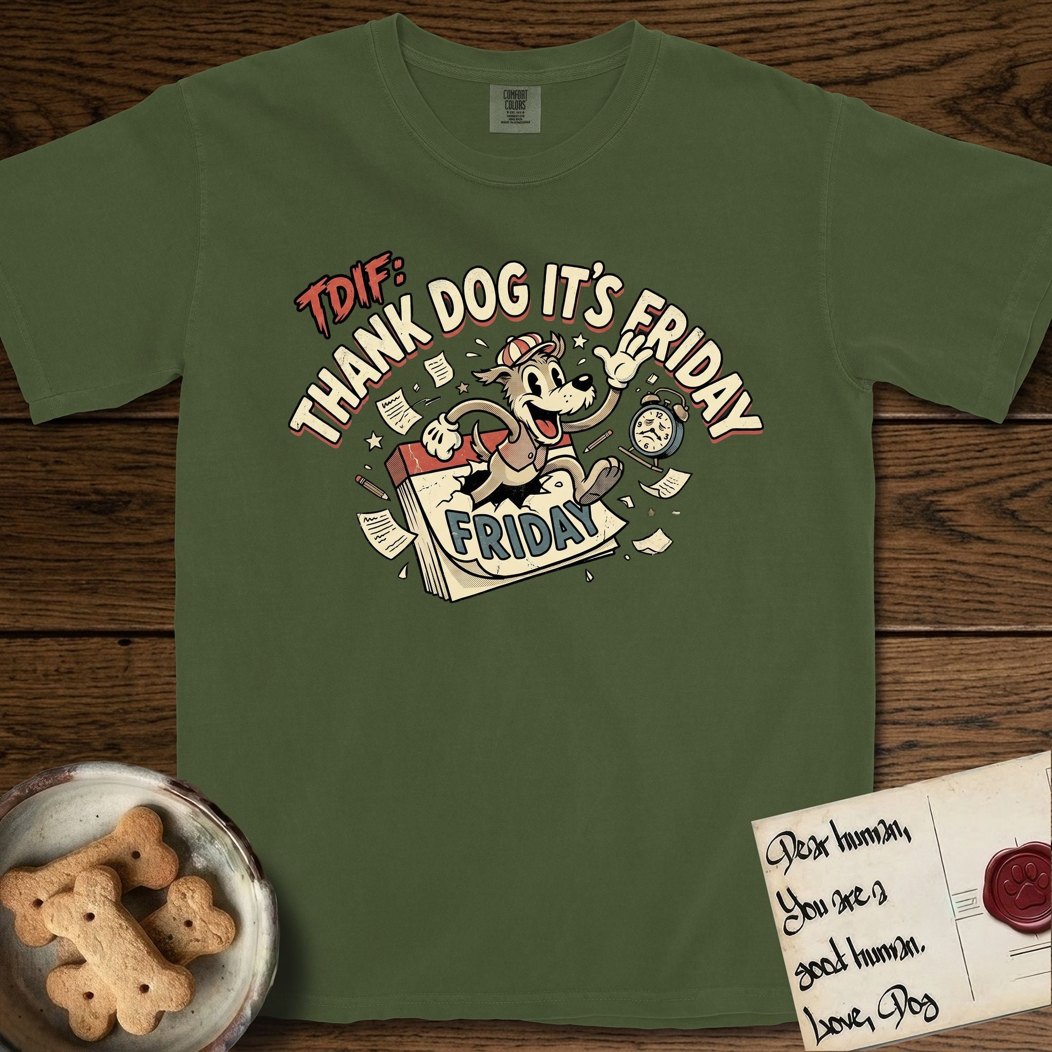 Thank Dog It's Friday T-Shirt flat lay in Hemp, featuring a retro 1930s cartoon of a Dog bursting through a Friday calendar page, surrounded by musical notes, stars, and a clock, with retro display lettering reading TDIF.