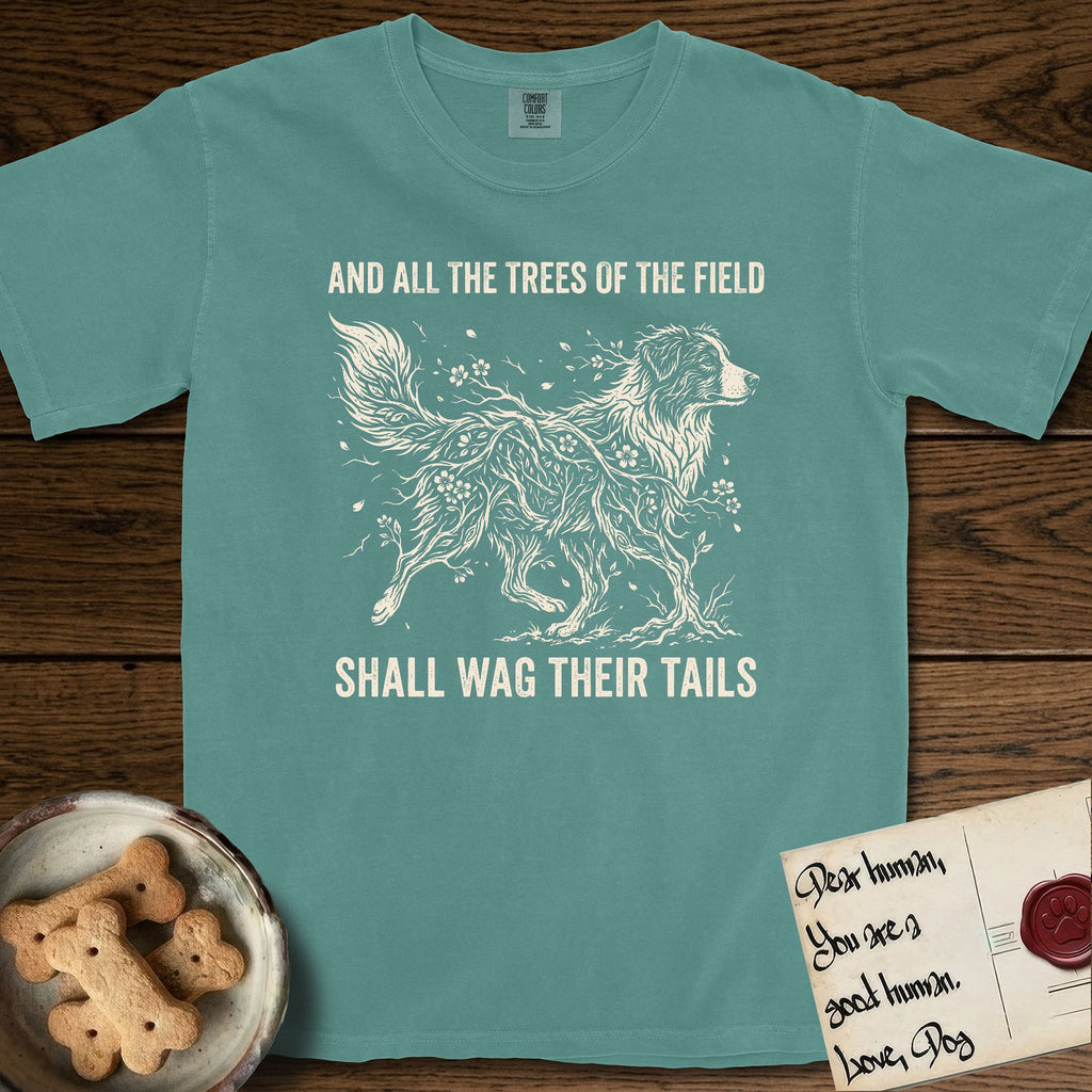 Trees of the Field Australian Shepherd T-Shirt flat lay in Blue Spruce, featuring a vintage woodcut illustration of an Australian Shepherd formed of flowering cherry branches, mid-stride, with the words And All the Trees of the Field Shall Wag Their Tails.