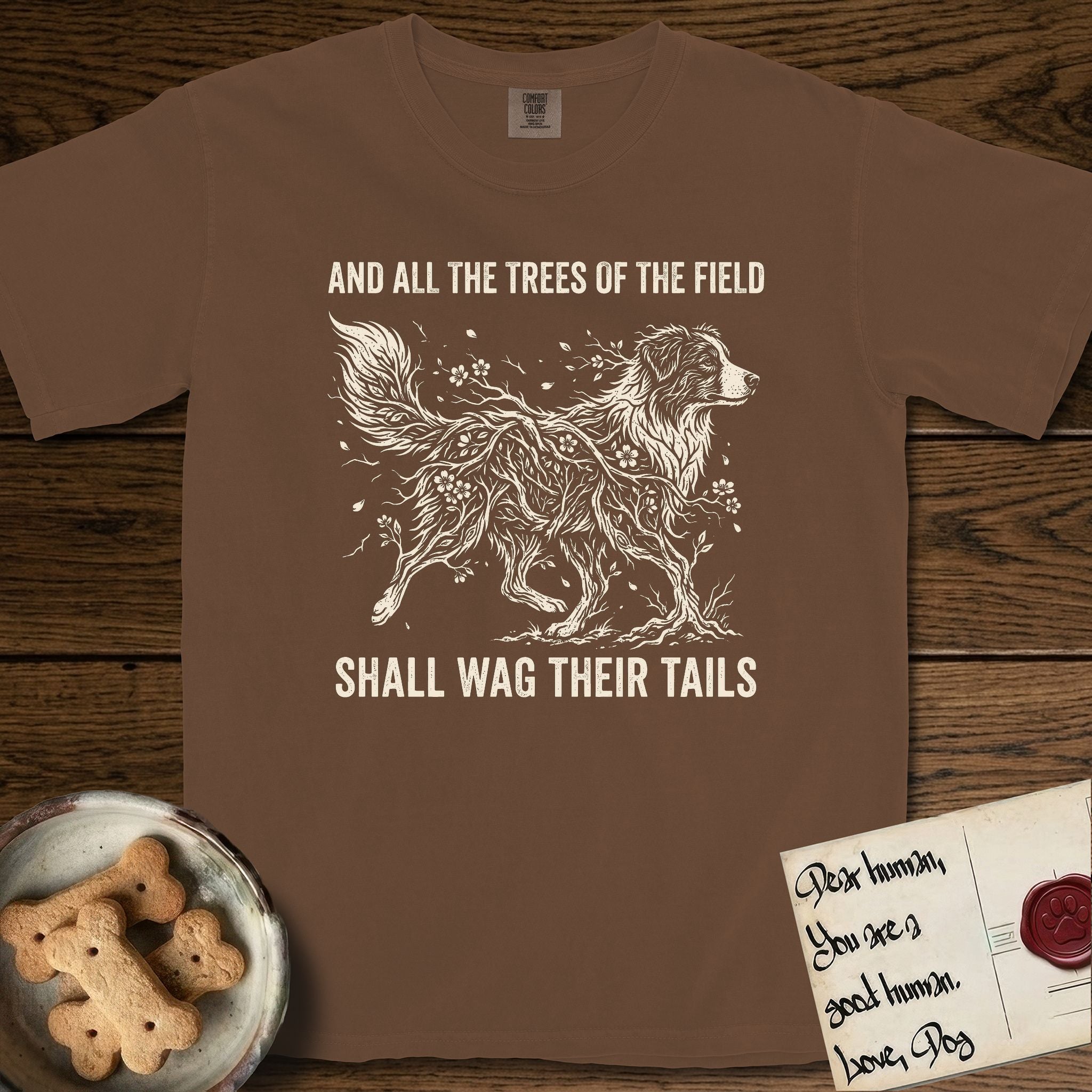 Trees of the Field Australian Shepherd T-Shirt flat lay in Espresso, featuring a vintage woodcut illustration of an Australian Shepherd formed of flowering cherry branches, mid-stride, with the words And All the Trees of the Field Shall Wag Their Tails.