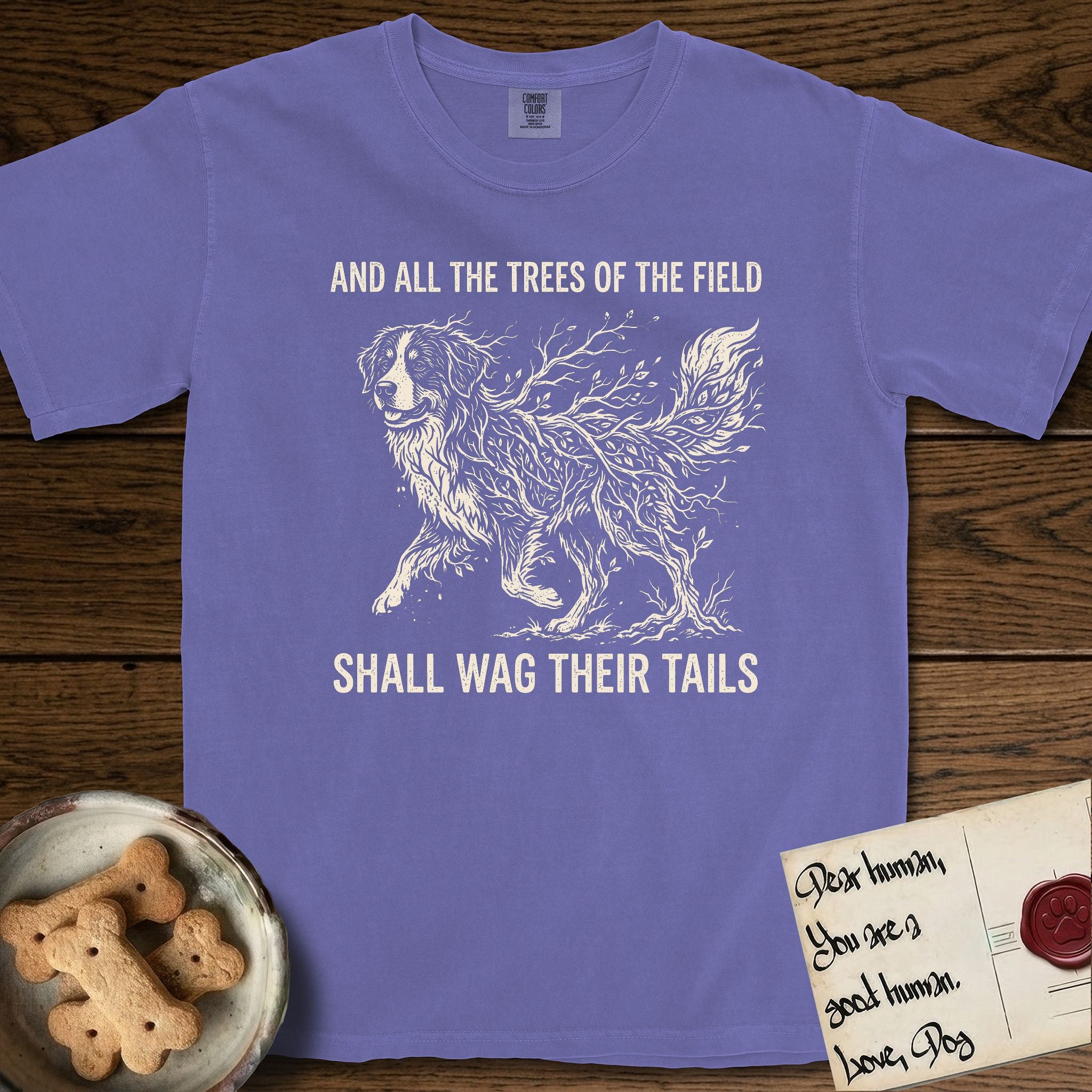 Trees of the Field Bernese Mountain Dog T-Shirt flat lay in Violet, featuring a vintage woodcut illustration of a Bernese Mountain Dog formed of bare windswept winter branches, mid-stride, with the words And All the Trees of the Field Shall Wag Their Tails.