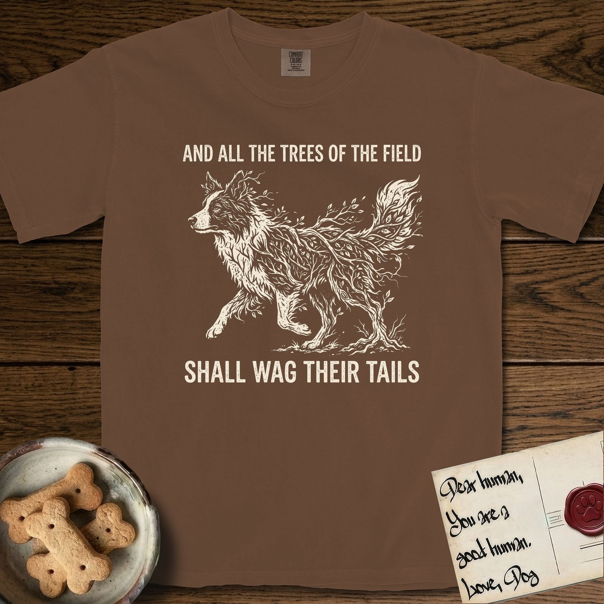 Trees of the Field Border Collie T-Shirt flat lay in Espresso, featuring a vintage woodcut illustration of a Border Collie formed of quaking aspen branches, mid-stride, with the words And All the Trees of the Field Shall Wag Their Tails.