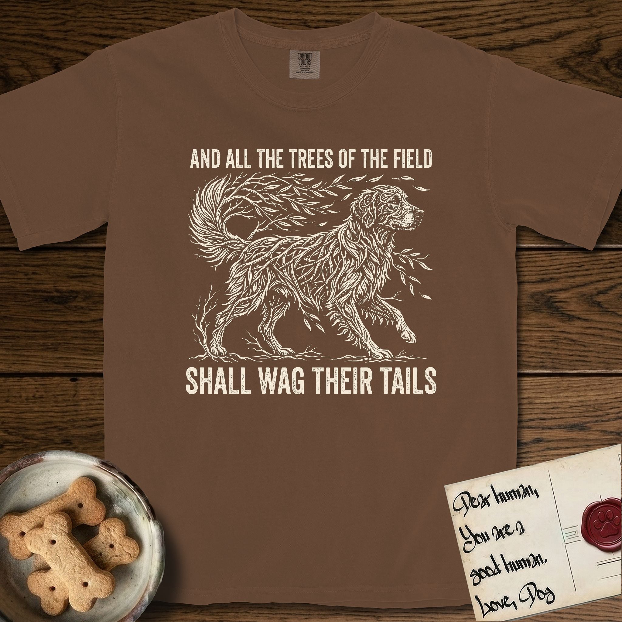 Trees of the Field Golden Retriever T-Shirt flat lay in Espresso, featuring a vintage woodcut illustration of a Golden Retriever formed of flowing willow branches, mid-stride, with the words And All the Trees of the Field Shall Wag Their Tails.