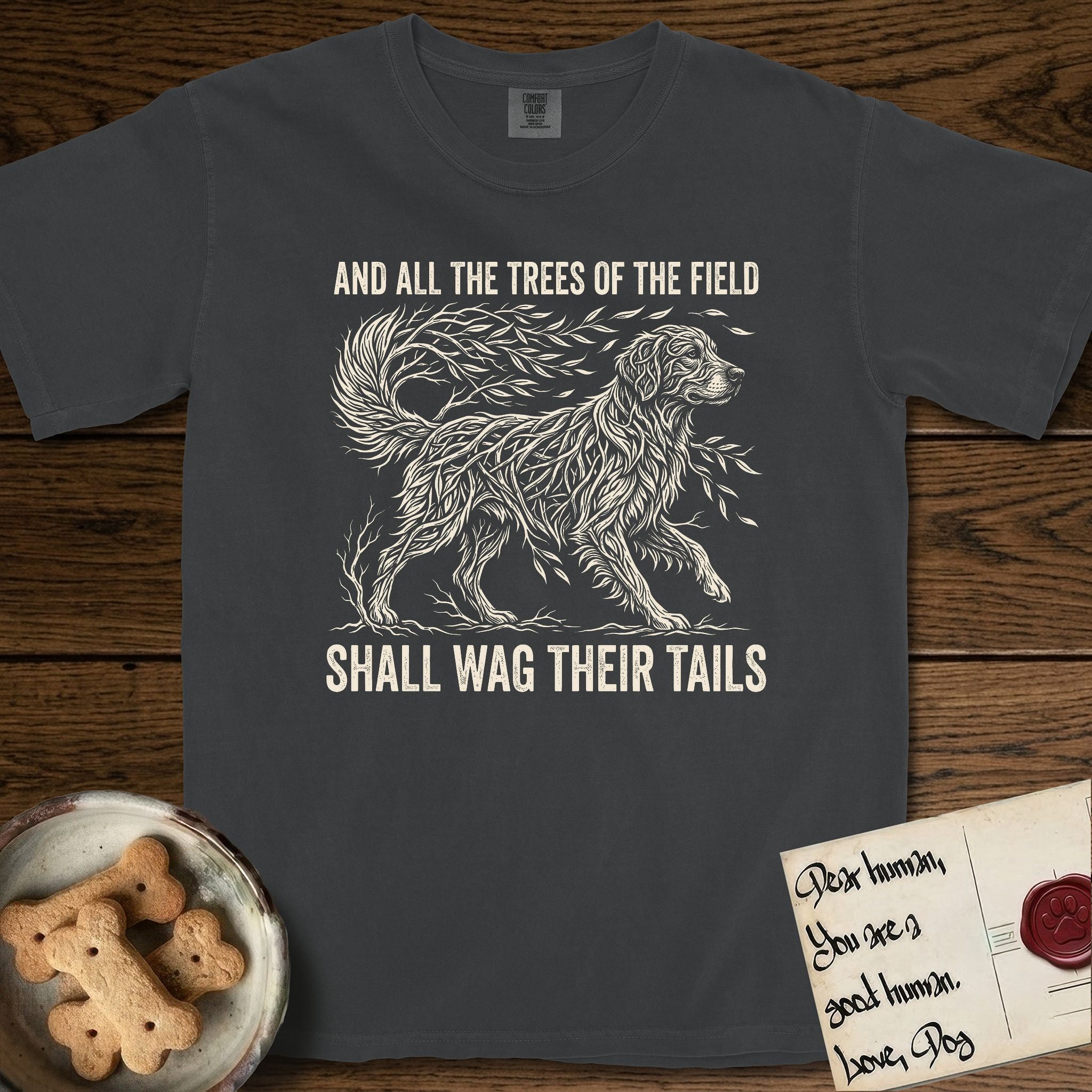 Trees of the Field Golden Retriever T-Shirt flat lay in Graphite, featuring a vintage woodcut illustration of a Golden Retriever formed of flowing willow branches, mid-stride, with the words And All the Trees of the Field Shall Wag Their Tails.
