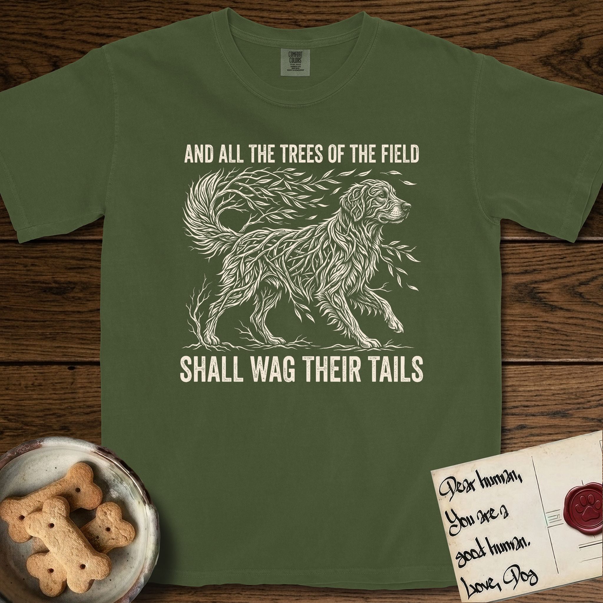 Trees of the Field Golden Retriever T-Shirt flat lay in Hemp, featuring a vintage woodcut illustration of a Golden Retriever formed of flowing willow branches, mid-stride, with the words And All the Trees of the Field Shall Wag Their Tails.