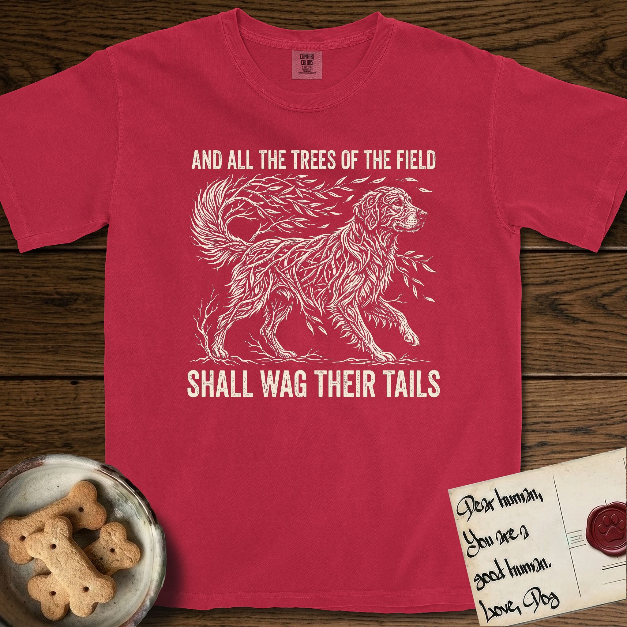 Trees of the Field Golden Retriever T-Shirt flat lay in Red, featuring a vintage woodcut illustration of a Golden Retriever formed of flowing willow branches, mid-stride, with the words And All the Trees of the Field Shall Wag Their Tails.