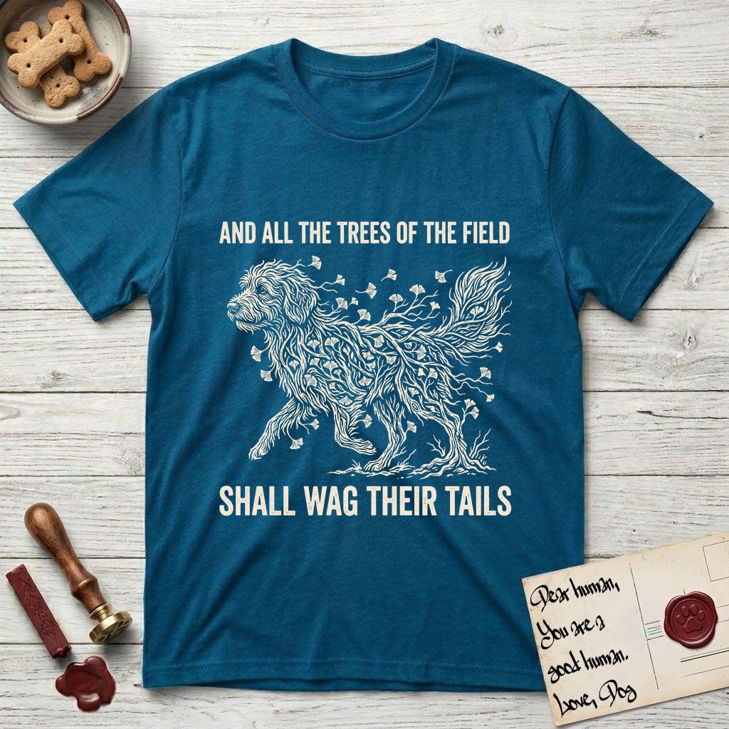 Trees of the Field Goldendoodle T-Shirt flat lay in Antique Sapphire, featuring a vintage woodcut illustration of a Goldendoodle formed of ginkgo branches with fan-shaped leaves, mid-stride, with the words And All the Trees of the Field Shall Wag Their Tails.