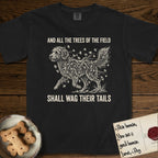 Trees of the Field Goldendoodle T-Shirt flat lay in Black, featuring a vintage woodcut illustration of a Goldendoodle formed of ginkgo branches with fan-shaped leaves, mid-stride, with the words And All the Trees of the Field Shall Wag Their Tails.