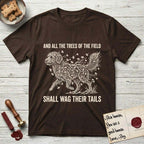 Trees of the Field Goldendoodle T-Shirt flat lay in Dark Chocolate, featuring a vintage woodcut illustration of a Goldendoodle formed of ginkgo branches with fan-shaped leaves, mid-stride, with the words And All the Trees of the Field Shall Wag Their Tails.