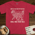 Trees of the Field Goldendoodle T-Shirt flat lay in Red, featuring a vintage woodcut illustration of a Goldendoodle formed of ginkgo branches with fan-shaped leaves, mid-stride, with the words And All the Trees of the Field Shall Wag Their Tails.