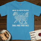 Trees of the Field Goldendoodle T-Shirt flat lay in Royal Caribe, featuring a vintage woodcut illustration of a Goldendoodle formed of ginkgo branches with fan-shaped leaves, mid-stride, with the words And All the Trees of the Field Shall Wag Their Tails.