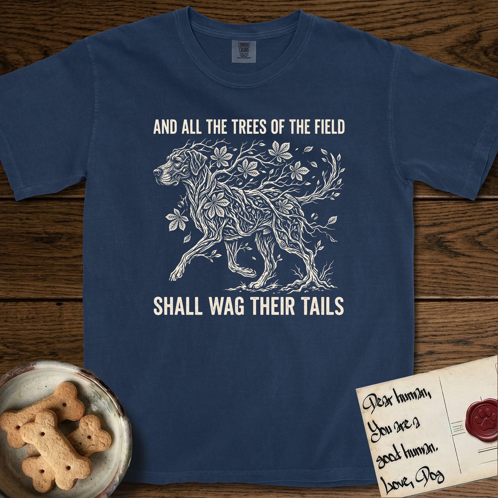 Trees of the Field Great Dane T-Shirt flat lay in True Navy, featuring a vintage woodcut illustration of a Great Dane formed of horse chestnut branches and leaves, mid-stride, with the words And All the Trees of the Field Shall Wag Their Tails.